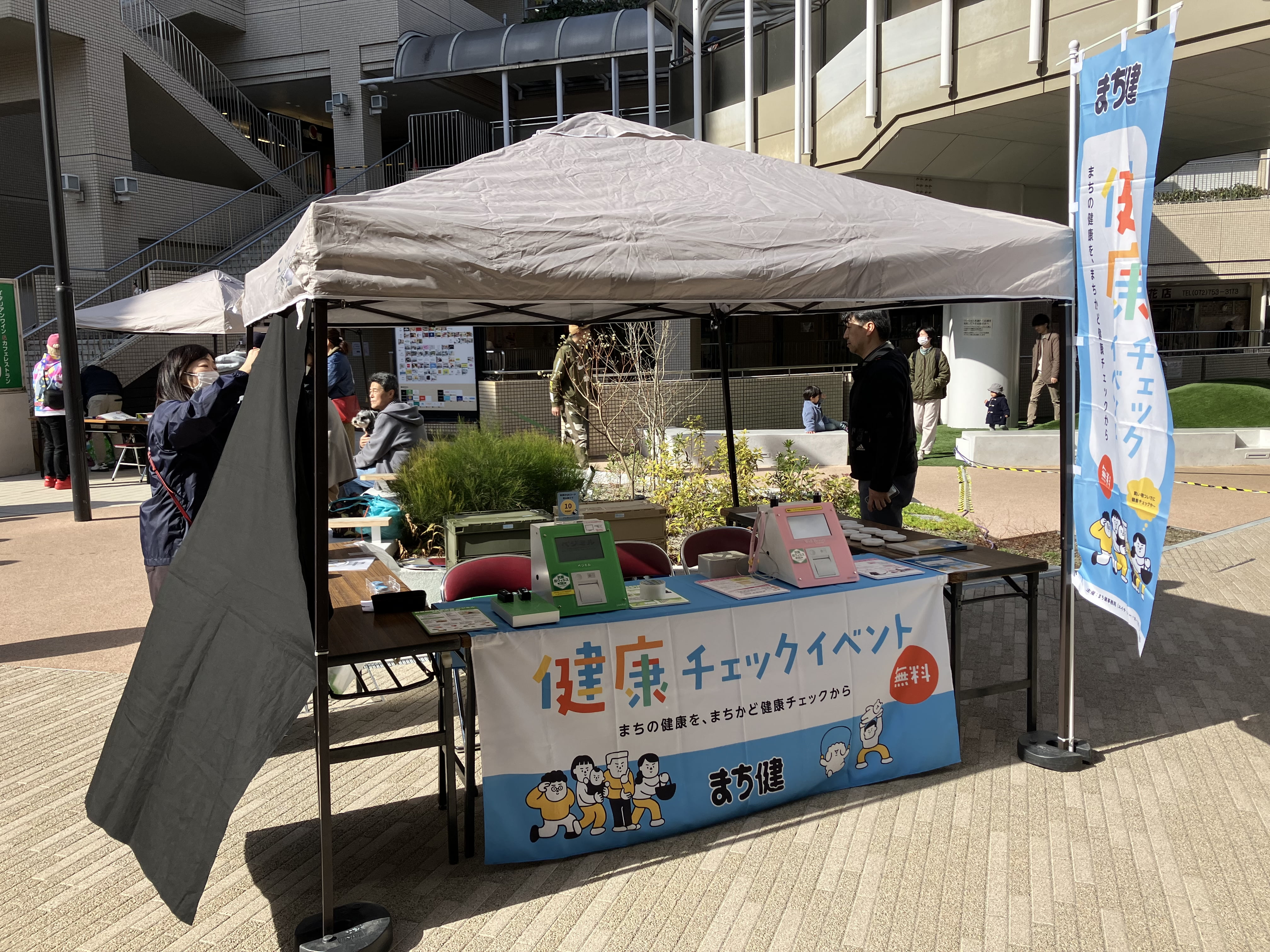 屋外イベントで健康チェックを案内している様子